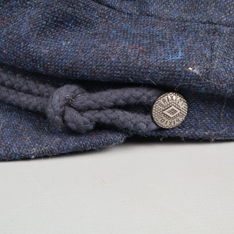 Close-up of cap's braid and button
