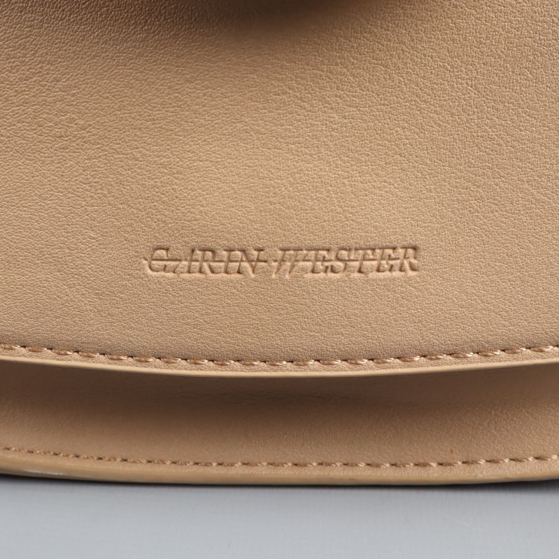 Logotyp på beige handväska