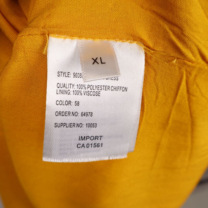 Materiallapp på gul klänning