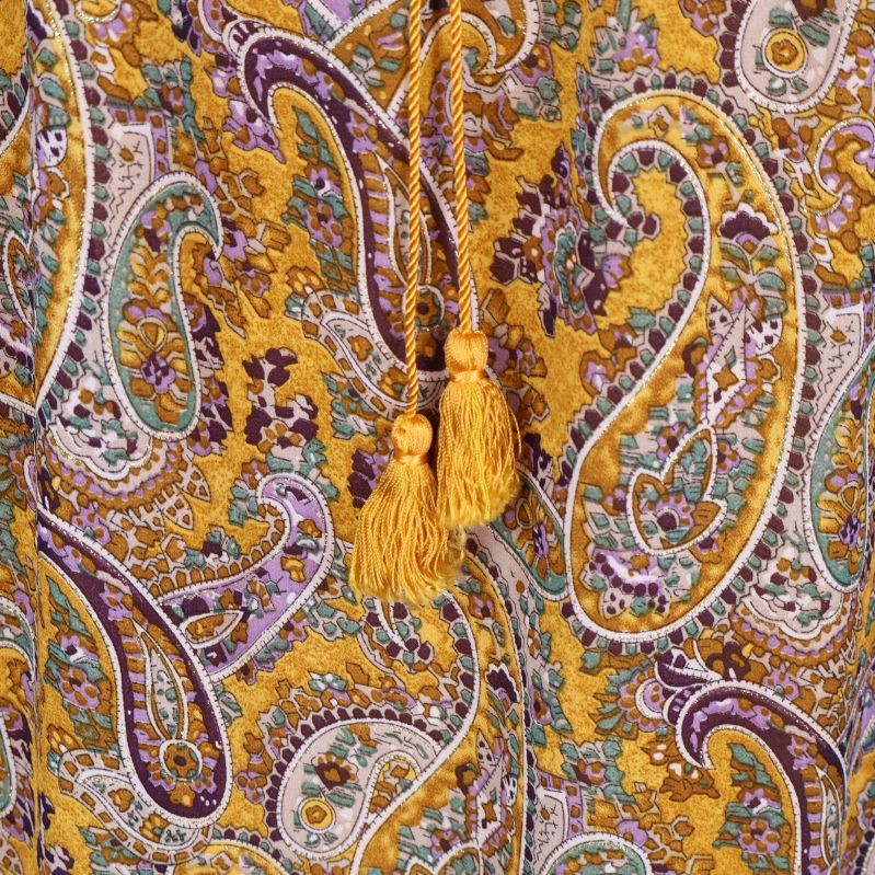 Detalj av tofsar och paisleymönster