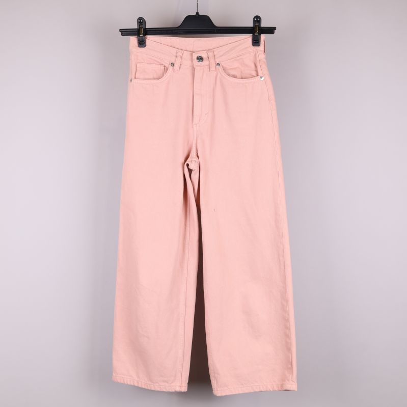 Framifrån av rosa jeans på galge