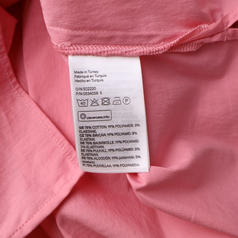 Materialetikett på rosa topp med komposition