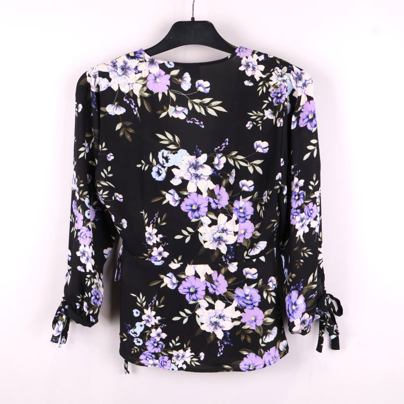 Baksidan av blommig omlottblus med lila blommor