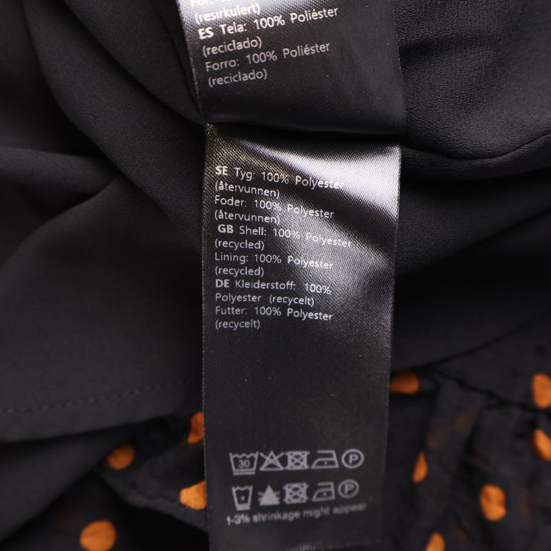 Klänningens materialetikett med 100% polyester