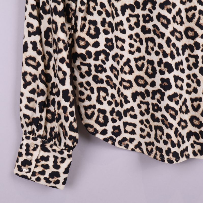 Närbild av ärmdetalj på leopardmönstrad blus