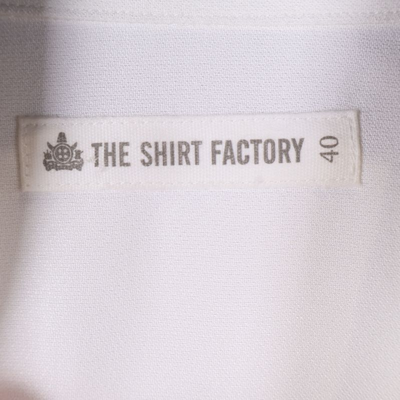 Märkesetikett från The Shirt Factory i vitt tyg