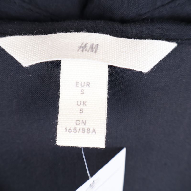 Närbild av H&M etikett på skjortklänning