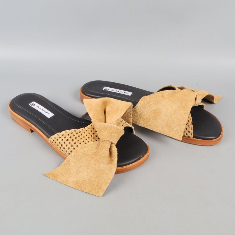 Sidovy av sandaler med stora rosetter