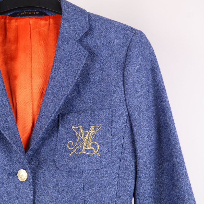 Närbild av bröstficka med broderat monogram