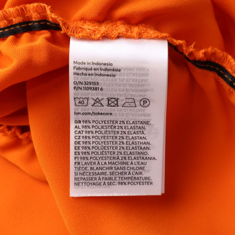Materialetikett på orange blus