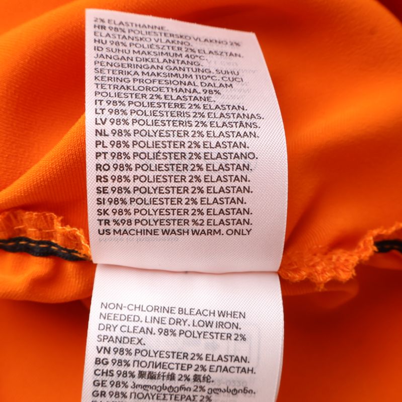 Tvättinstruktioner på orange blus