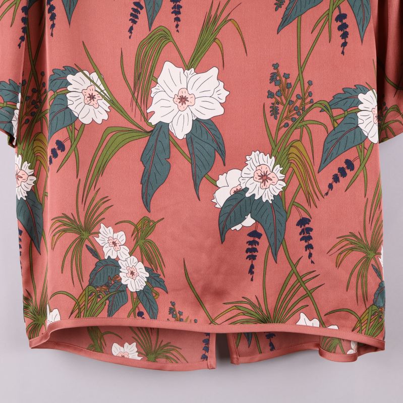 Nedre del av blommig topp med fållad kant