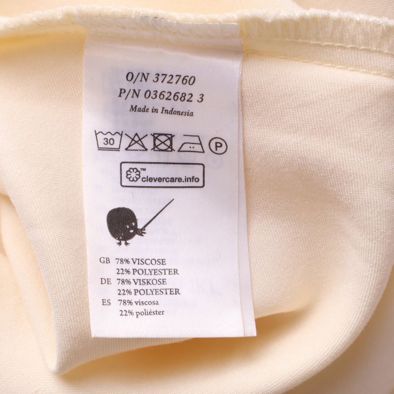 Materialetikett visar viskos och polyester