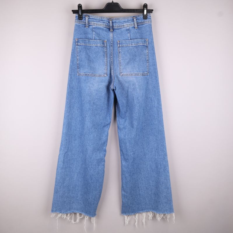 Baksidan av jeans med fickor och fransar