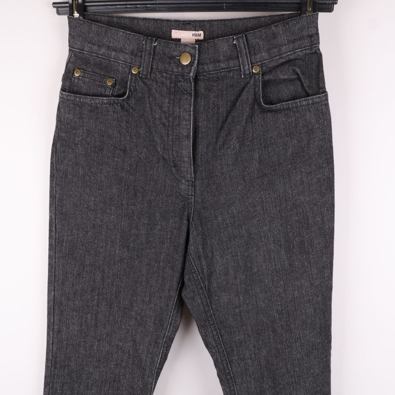 Övre del av grå jeans med knappar