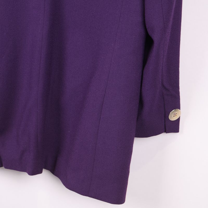 Närbild på blazerns ärm med knapp