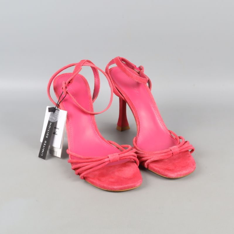 Sida av rosa sandaler med klack