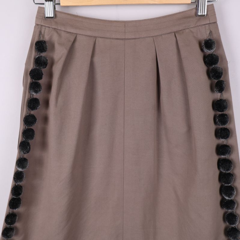 Närbild på pom-poms på sidan av kjolen