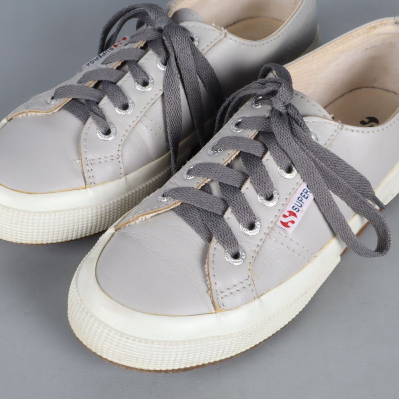 Grå sneakers med snörning och logotyp