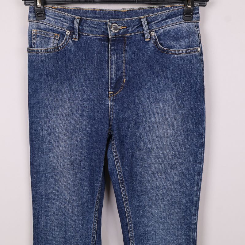 Närbild på jeans framfickor och knäppning