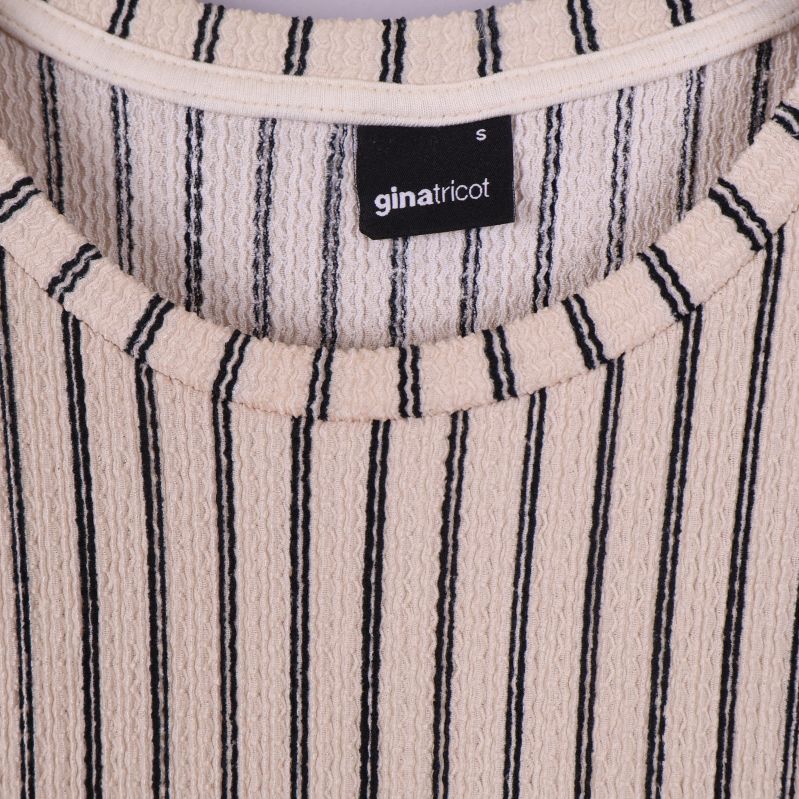 Närbild på Gina Tricot-etikett på klänningsinsida
