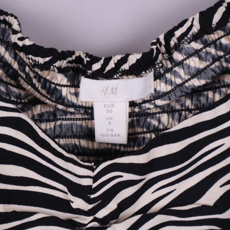 Närbild på blusens storleksetikett med H&M logga