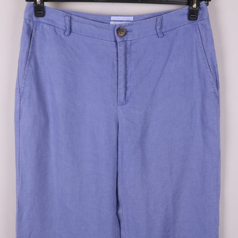 Övre del av blå linneshorts med knappdetalj
