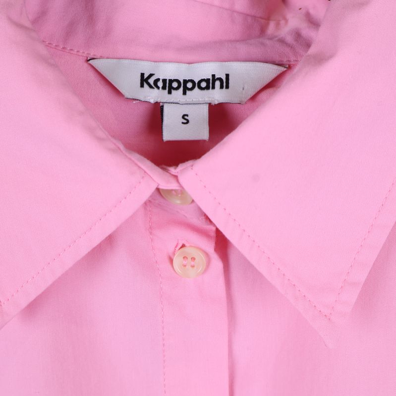 Kappahl märkning och svart knapp på rosa skjorta