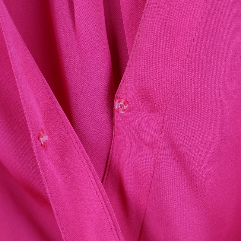 Närbild på rosa blusens knapphål