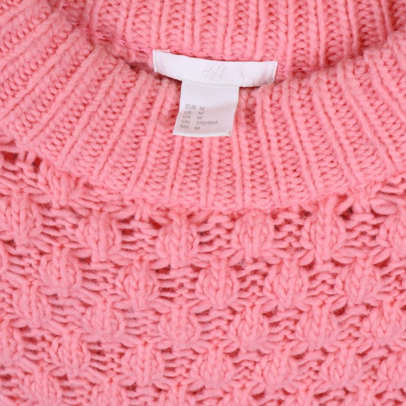 Närbild av hals och etikett på rosa tröja