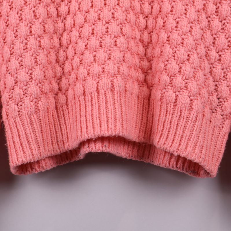 Närbild av nederdelen på rosa stickad tröja