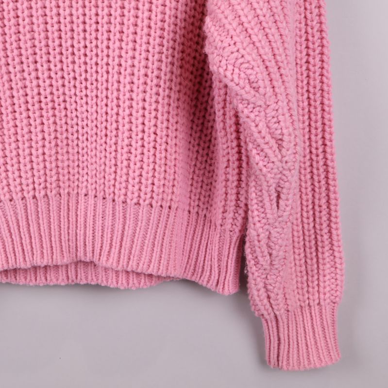 Närbild på ärmen av rosa stickad tröja