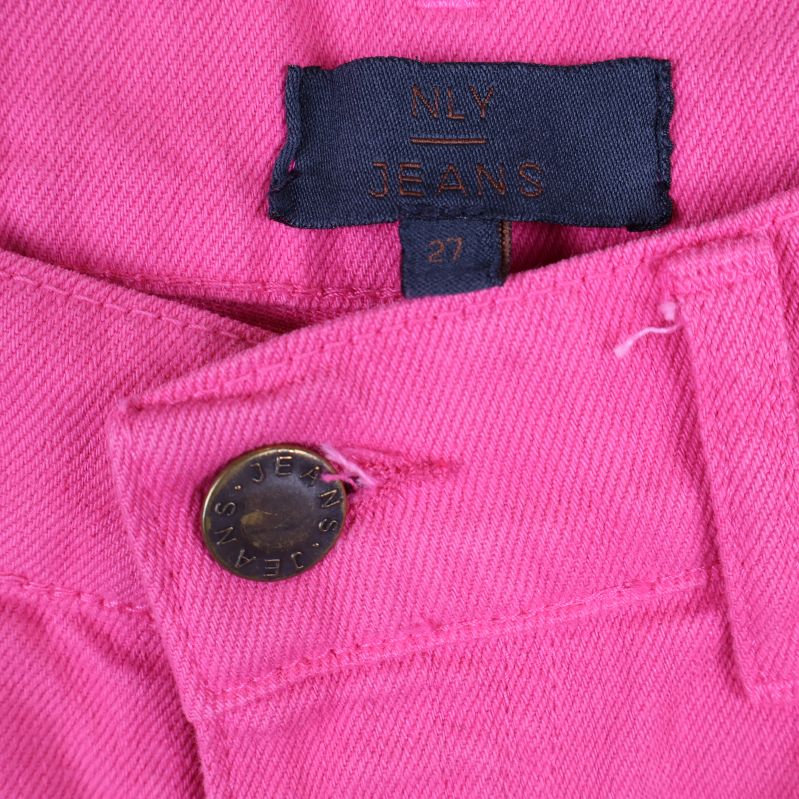 Närbild på NLY Jeans etikett och knapp