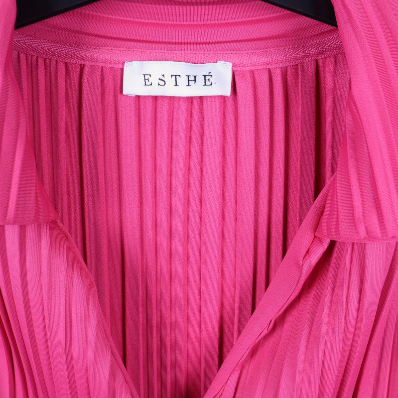 Närbild av Esthé etiketten i cerise skjorta