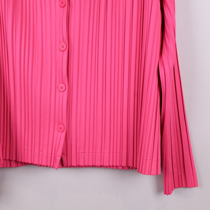 Detalj av plisserad ärm på cerise skjorta