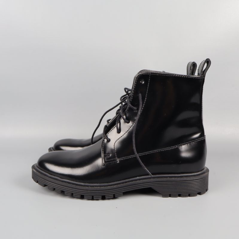 Sidovy av glänsande svarta snörstövlar i läder