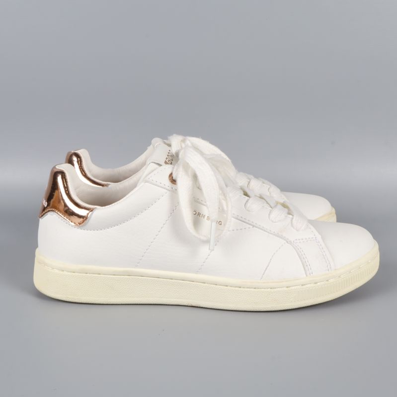 Profilbild av vita sneakers med koppardetaljer