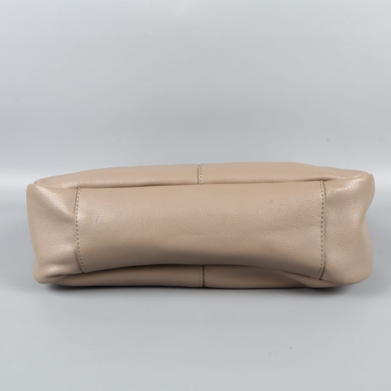 Bottenvy av beigefärgad axelväska