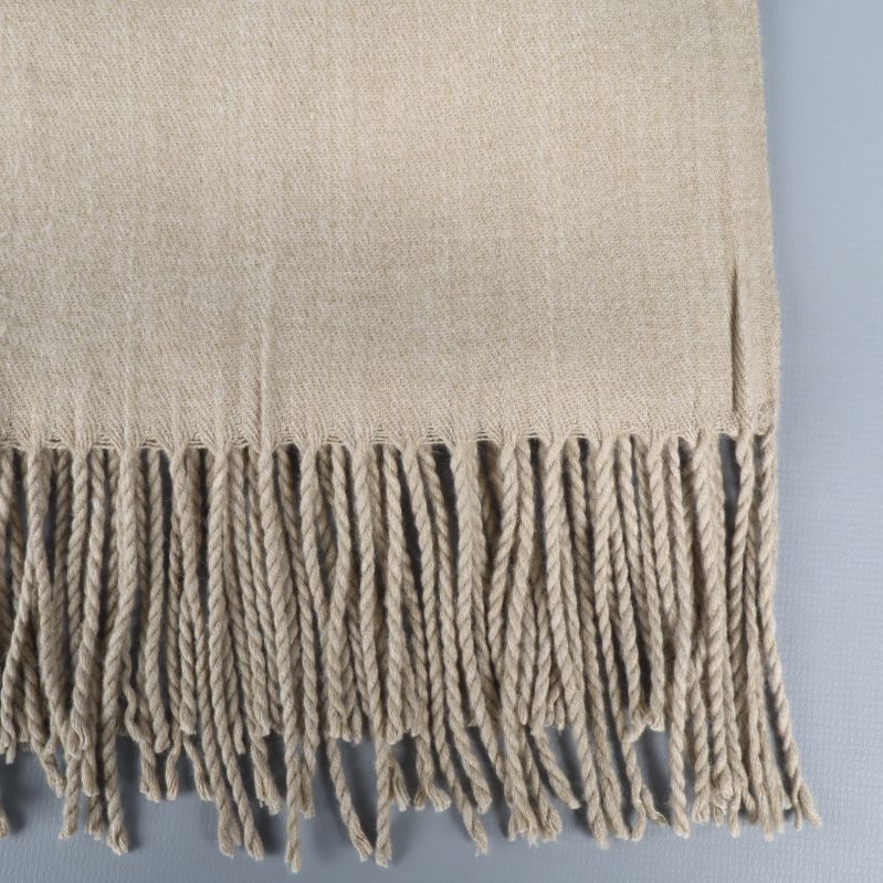 Detalj av beige halsduk med fransar