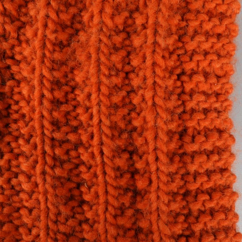 Närbild på texturen av orange stickad halsduk