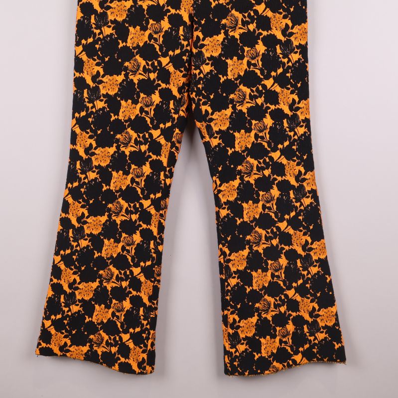 Nedre del av blommiga byxor med orange och svart design