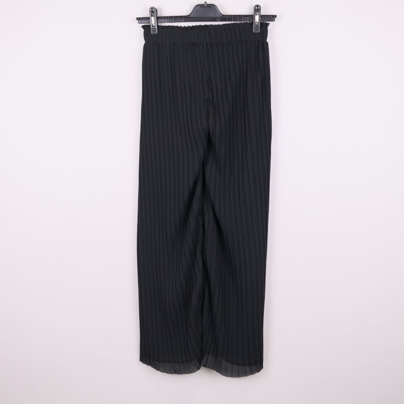 Baksidan av svarta plisserade byxor 