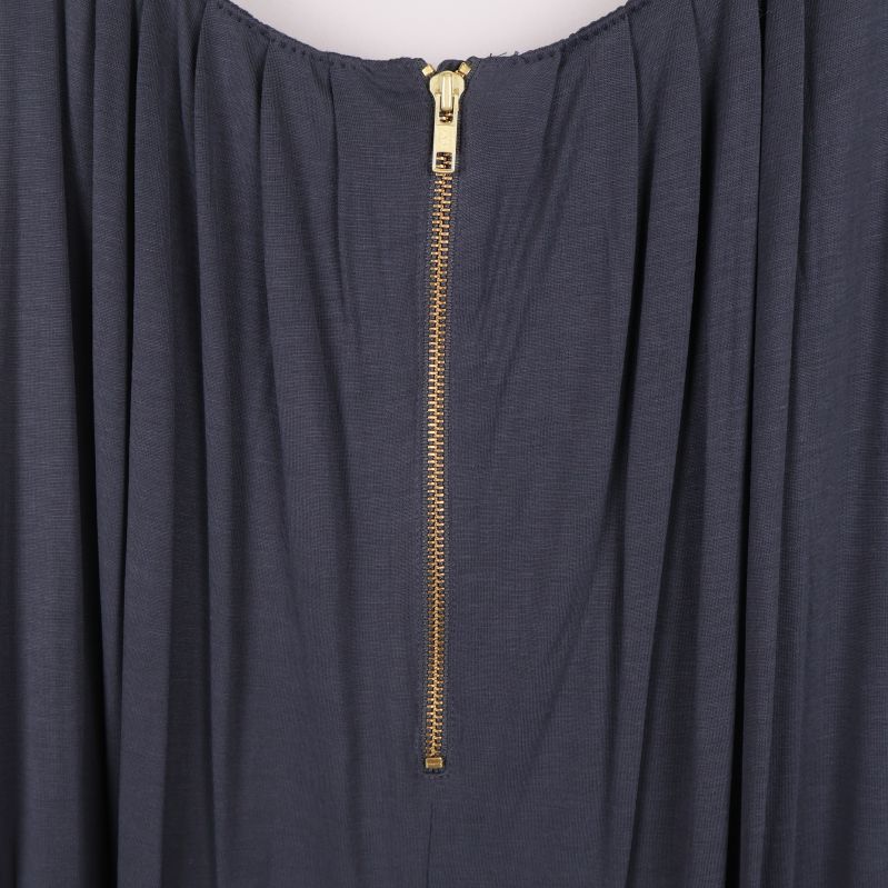 Närbild på guldfärgad dragkedja på baksidan av klänningen