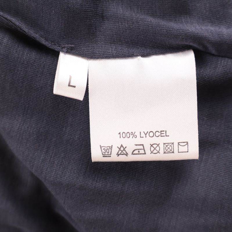 Vitt materialmärke med texten 100% Lyocell samt storlek L