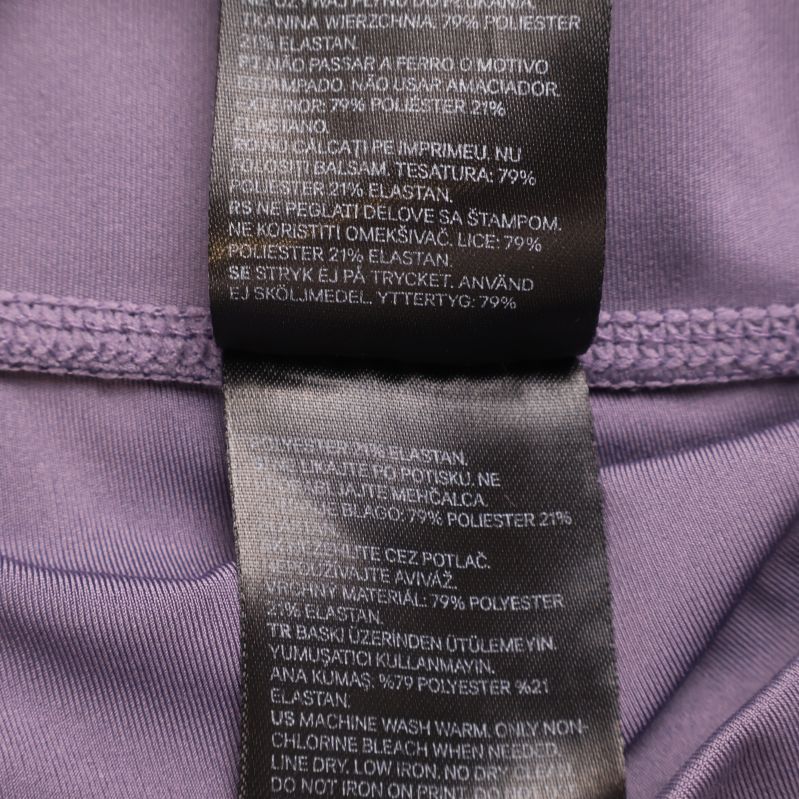 Materialetikett med sammansättning 79% polyester, 21% elastan