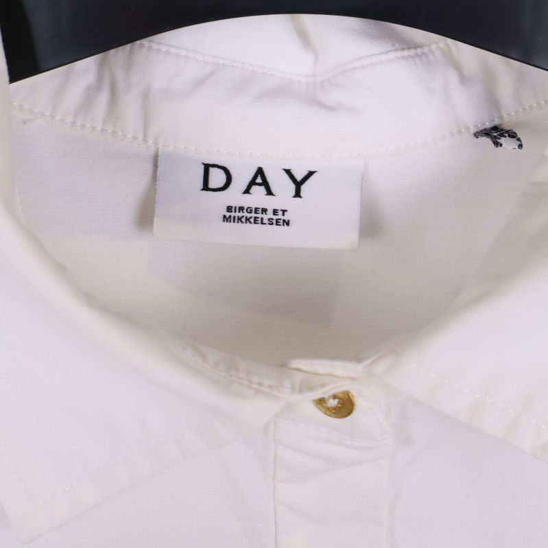 Närbild på vit skjortkrage med DAY-märke