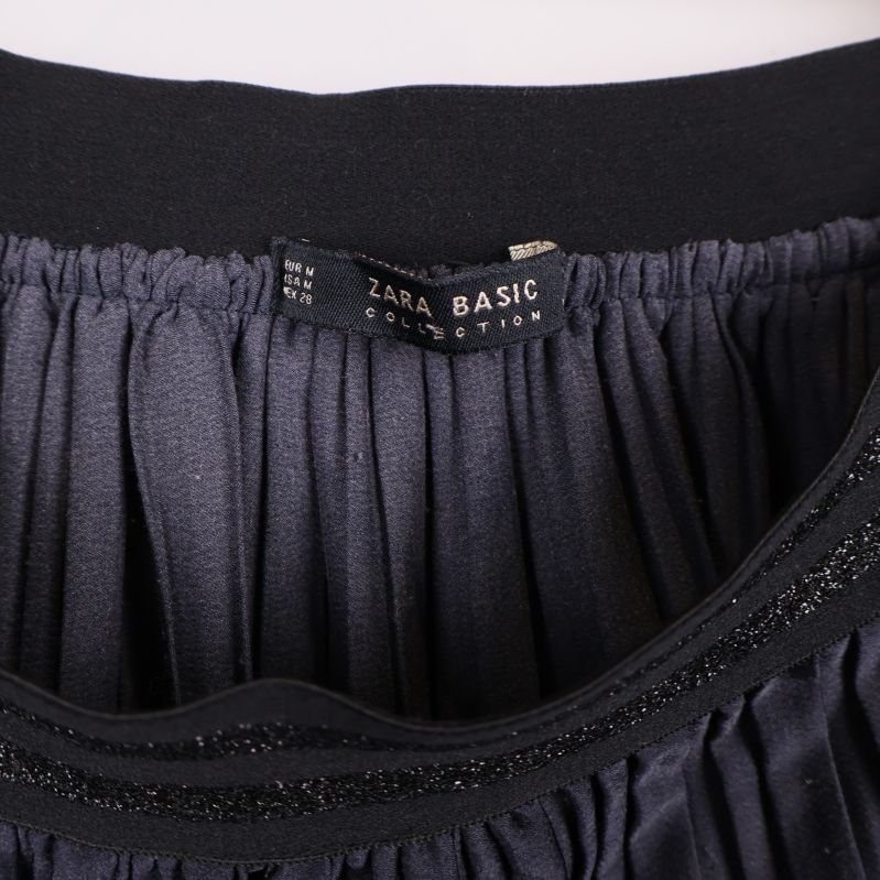 Närbild på svart resår och Zara Basic-etikett inuti kjolen