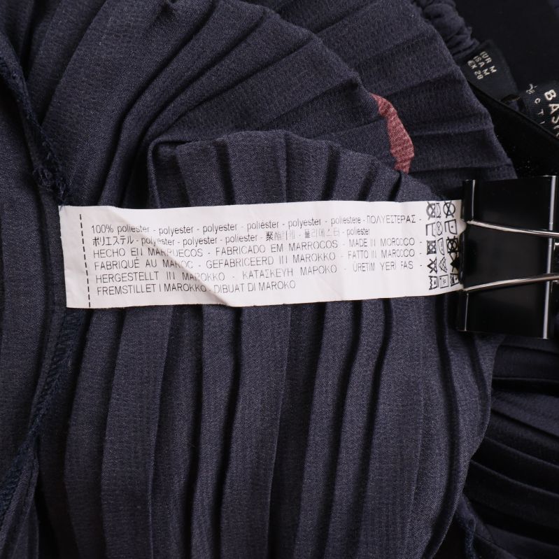 Materiallapp med texten 100% polyester i vit bakgrund