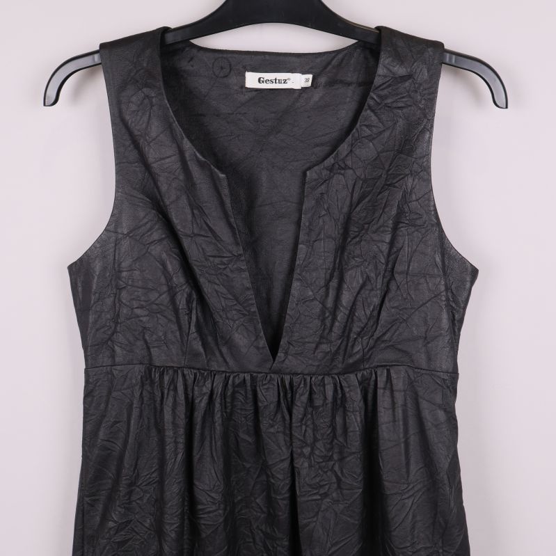 Närbild på överdelen av svart klänning med v-ringning