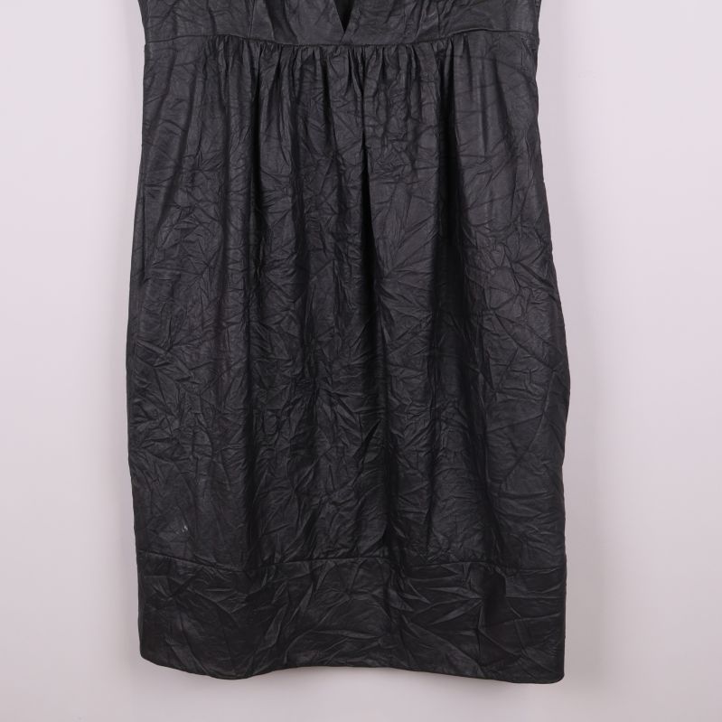 Närbild på nederdelen av klänningen med strukturerat tyg